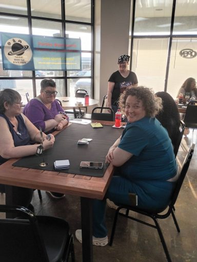 One player looks at the camera as four players play Uno